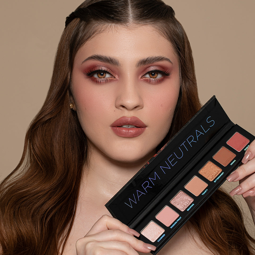 Model holding Sigma Beauty Warm Neutrals Mini 7-Shade Eyeshadow Palette
